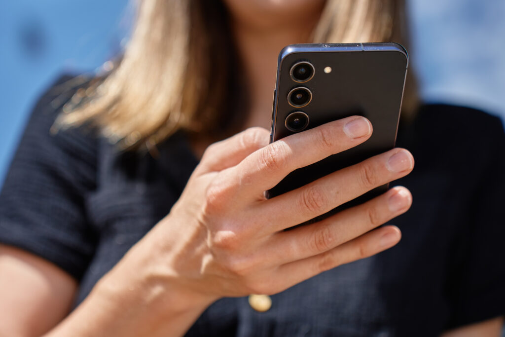 close up of woman holding smartphone in hand outdo 2026 01 08 08 16 22 utc